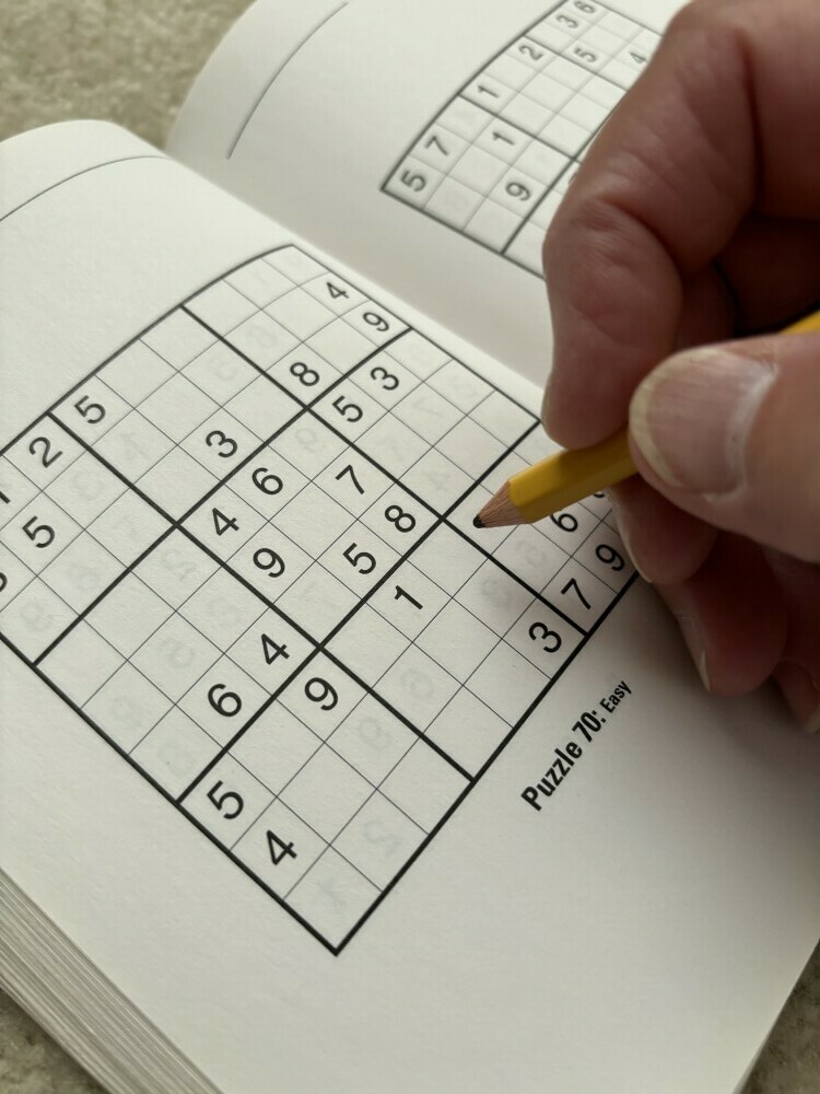 picture of someone with pencil about to start hard copy puzzle as an alternative to make a Sudoku puzzle for free