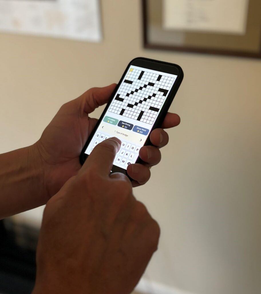 Person on smartphone demonstrating free crossword puzzle apps.