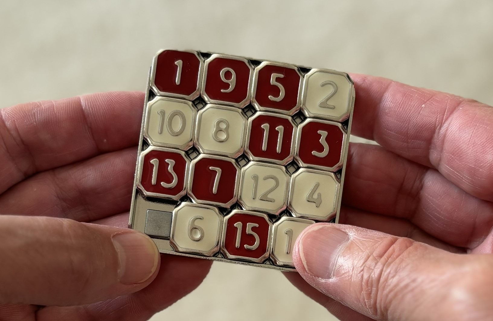 Person holding 15 tile sliding tile puzzle