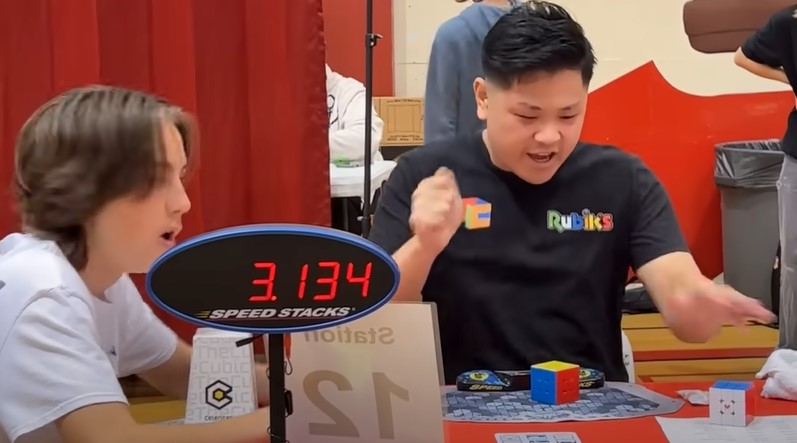 Picture of Max Park and judge during setting of 3x3 world record in 2023 with time of 3.134 seconds on timer.