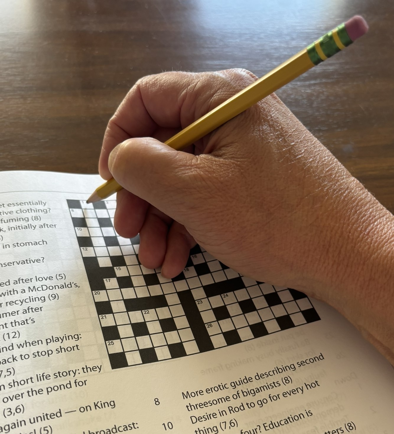 Hand with pencil in it about to solve crossword puzzle